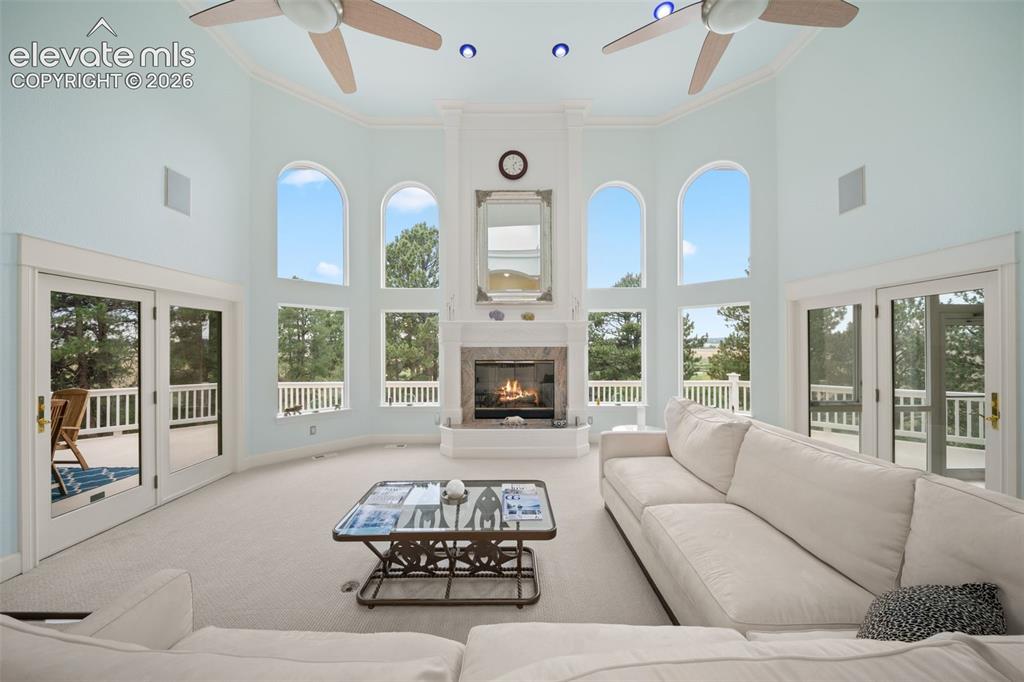Image 6 of 50: Vaulted ceiling with dual ceiling fans, arched windows, built-in fireplace,