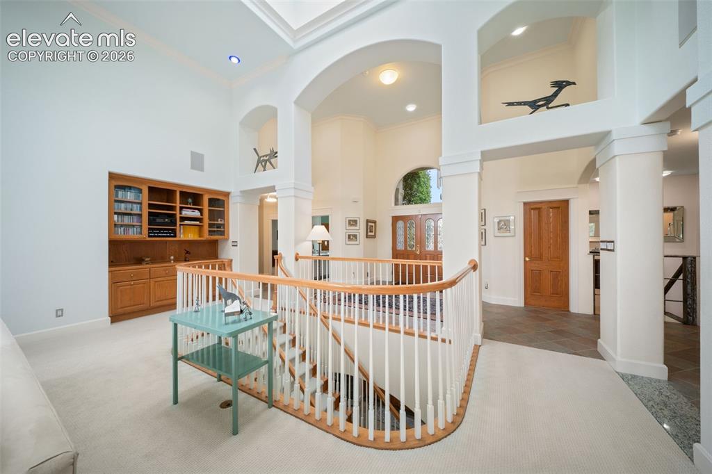 Image 9 of 50: Archways and columns defining distinct areas, built-in cabinetry with glass