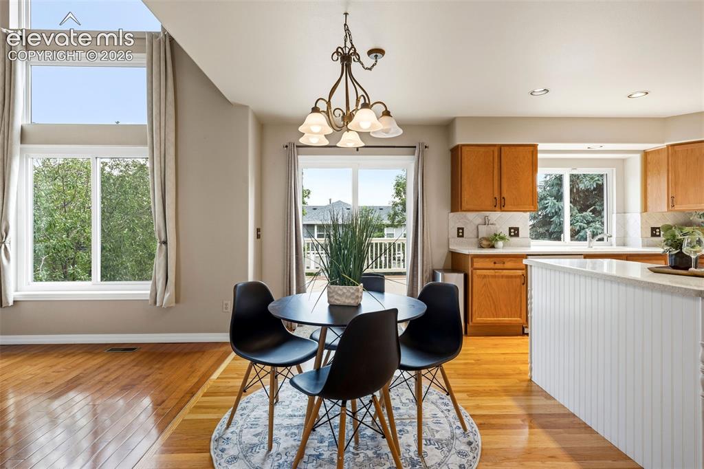 Image 13 of 50: Open-concept dining and kitchen area with wood-finish flooring