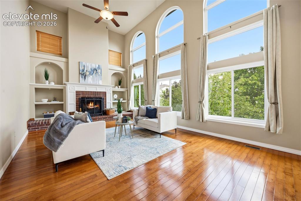 Image 14 of 50: Voluminous living space featuring tall ceilings and wood-finish flooring