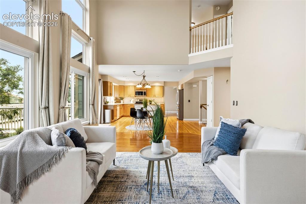 Image 18 of 50: Two-story living area with high ceilings and expansive windows