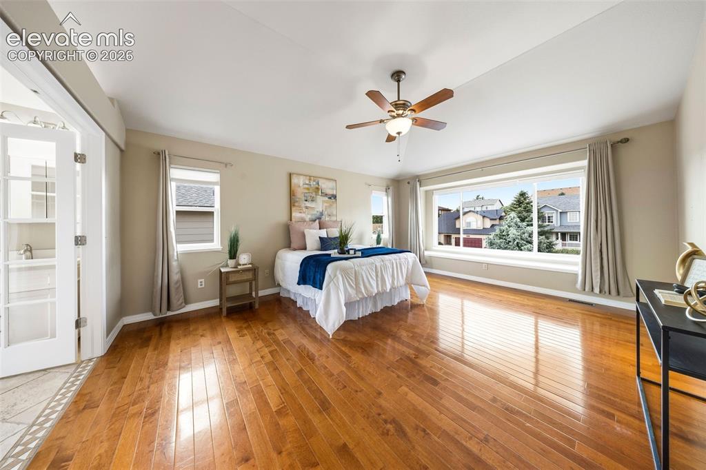 Image 22 of 50: Expansive room featuring rich wood-finish flooring and a wide picture windo