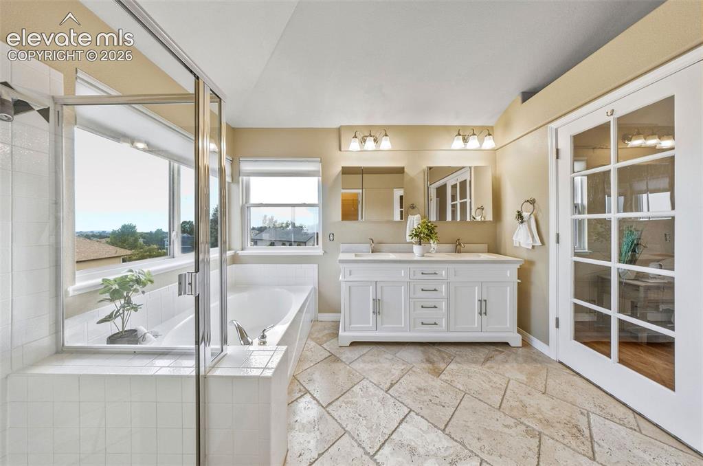 Image 27 of 50: Spacious bathroom featuring a dual vanity with white cabinetry and undermou