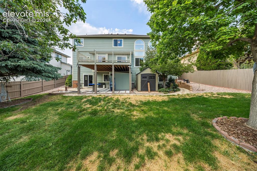 Image 45 of 50: Two-story exterior with a second-level deck, ground-level patio, and detach