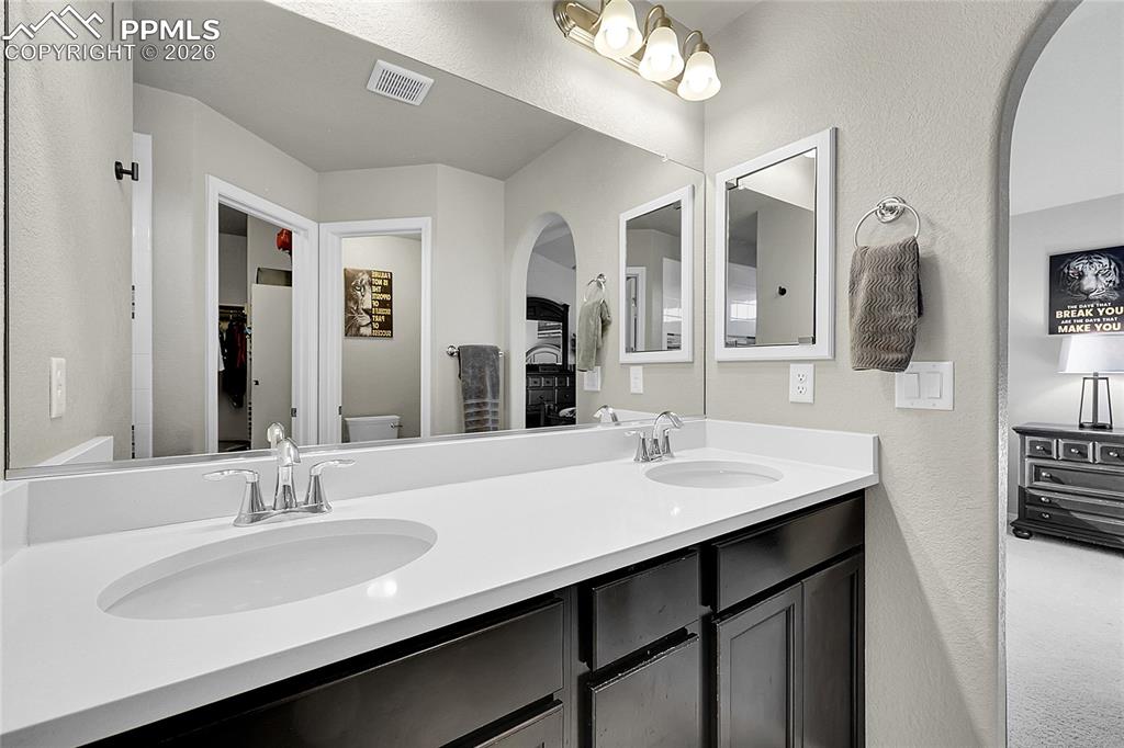 Image 17 of 42: En-suite bathroom features dual vanity