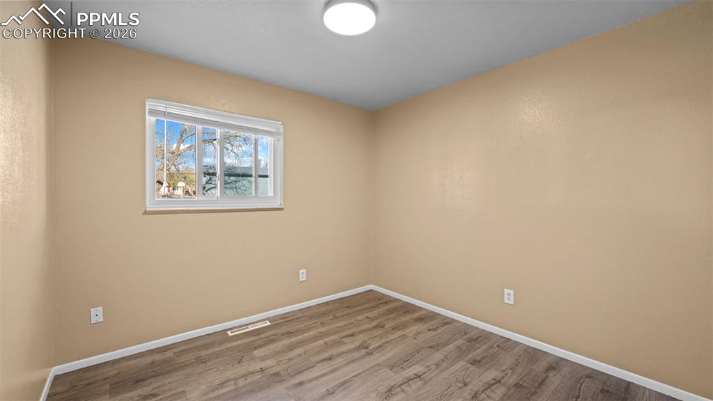 Image 12 of 23: Spare room featuring wood finished floors and baseboards