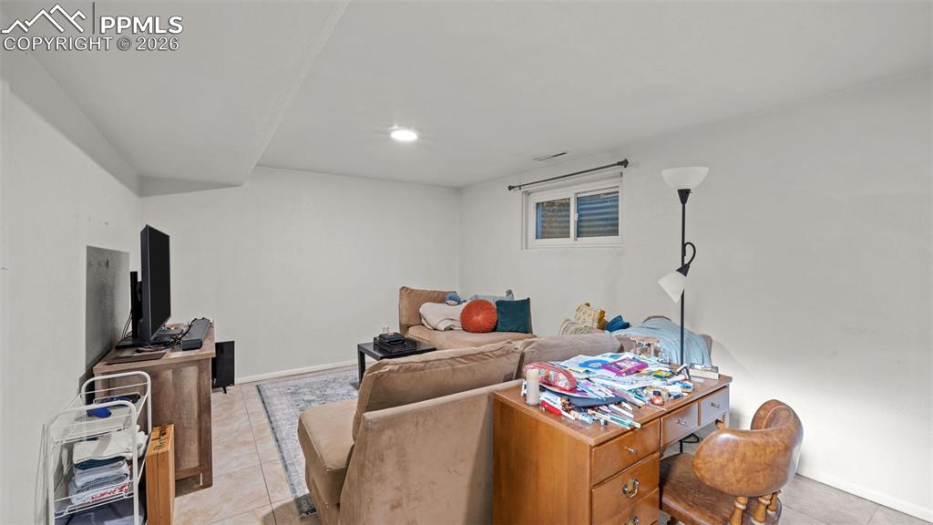 Image 12 of 22: Living area with light tile patterned floors and baseboards