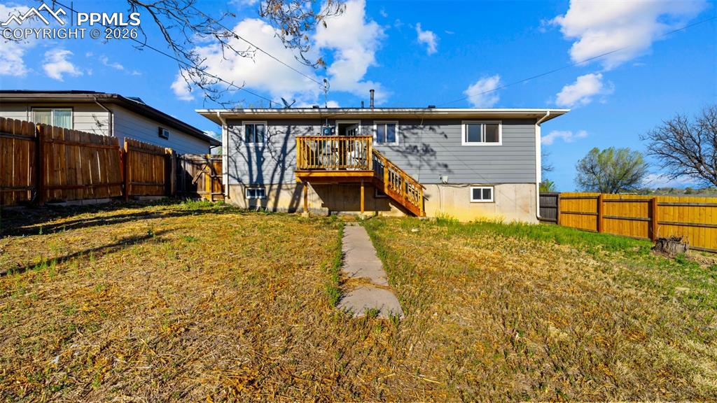 Image 19 of 22: Back of house with a fenced backyard and a wooden deck