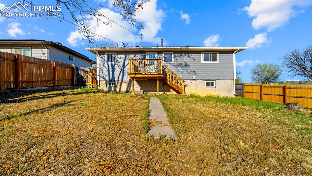 Image 20 of 22: Back of house with a fenced backyard and a deck