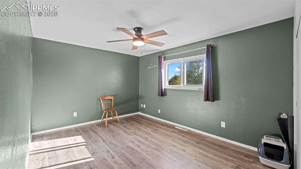 Image 9 of 22: Empty room featuring light wood-style flooring, ceiling fan, and a textured