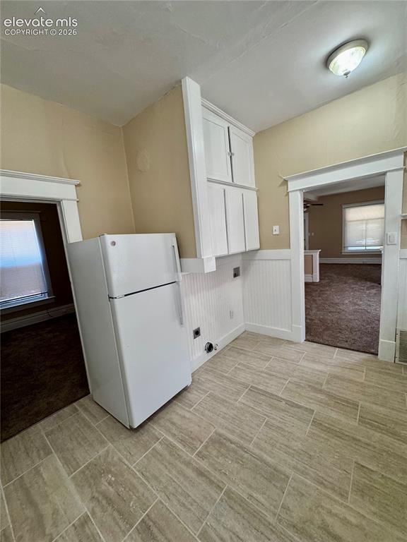 Image 15 of 50: Clawfoot bathtub with chrome fixtures, white toilet, tiled flooring, and a