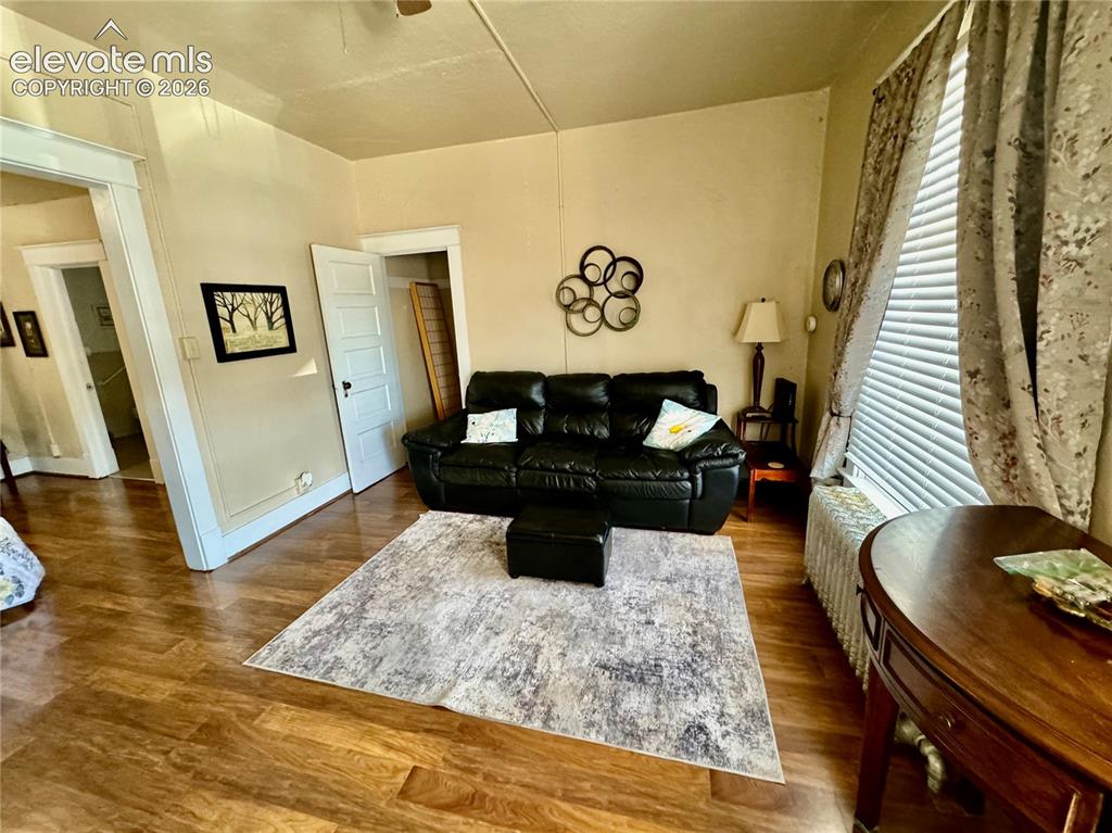 Image 16 of 48: Wood-finish flooring throughout, complemented by a window with horizontal b
