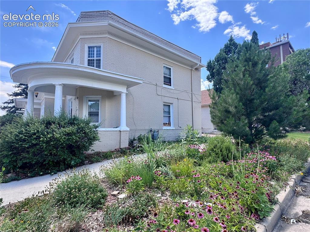 Image 2 of 50: Property exterior with a curved front porch, round columns, and a brick fac