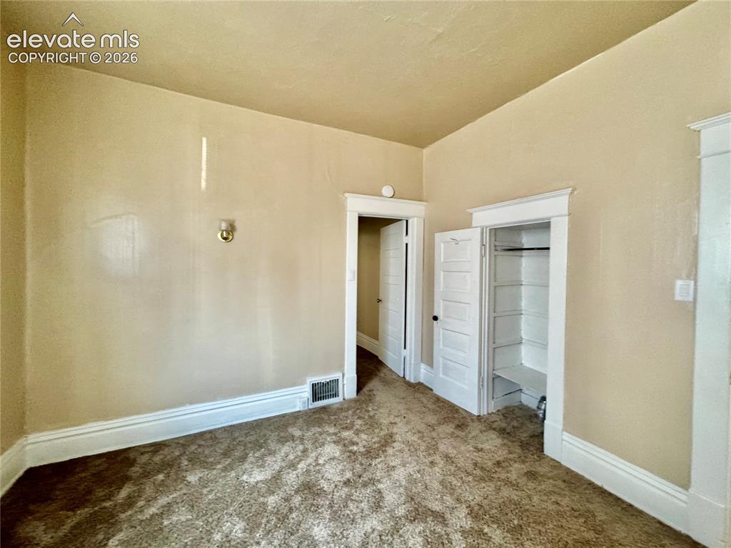 Image 28 of 48: Spacious bedroom with neutral wall finishes, carpeted flooring, and abundan
