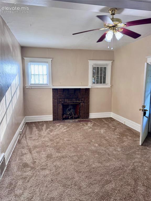 Image 36 of 48: Brick fireplace feature, two windows with grilles, ceiling fan with integra