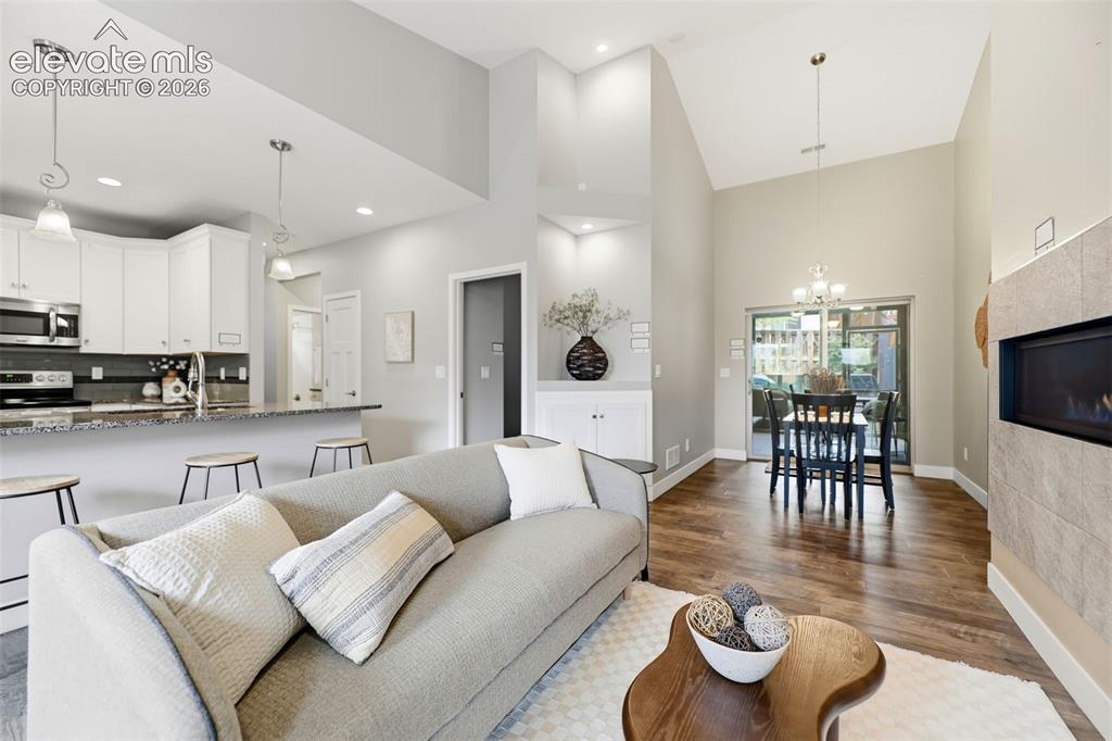 Image 4 of 42: Living Room showing Fireplace, Dining Area & Sliding Glass Door to Patio