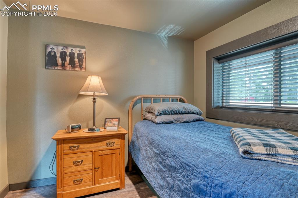 Image 11 of 48: Bedroom featuring a textured wall and baseboards