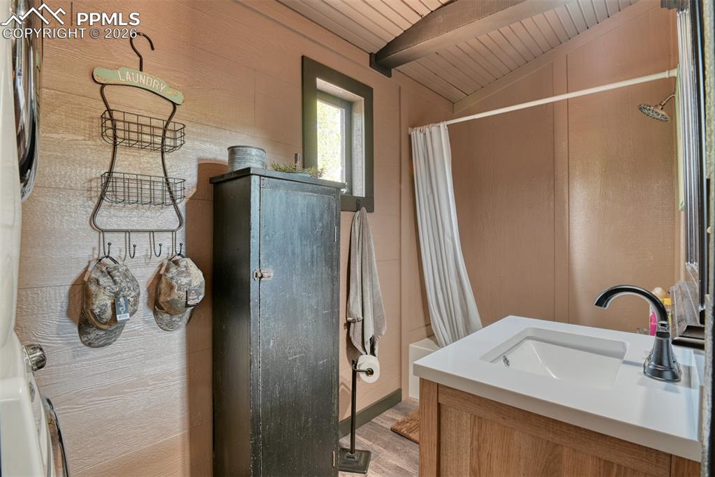 Image 12 of 48: Full bath featuring a shower with curtain, vanity, a vaulted wooden ceiling