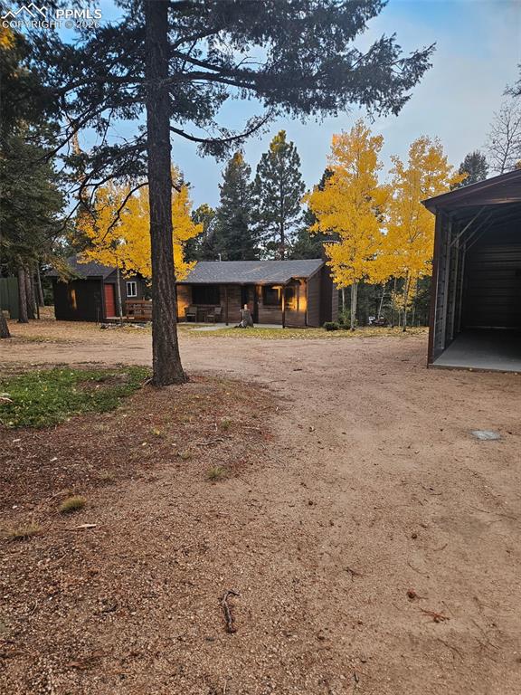 Image 43 of 48: View of yard featuring driveway and a carport