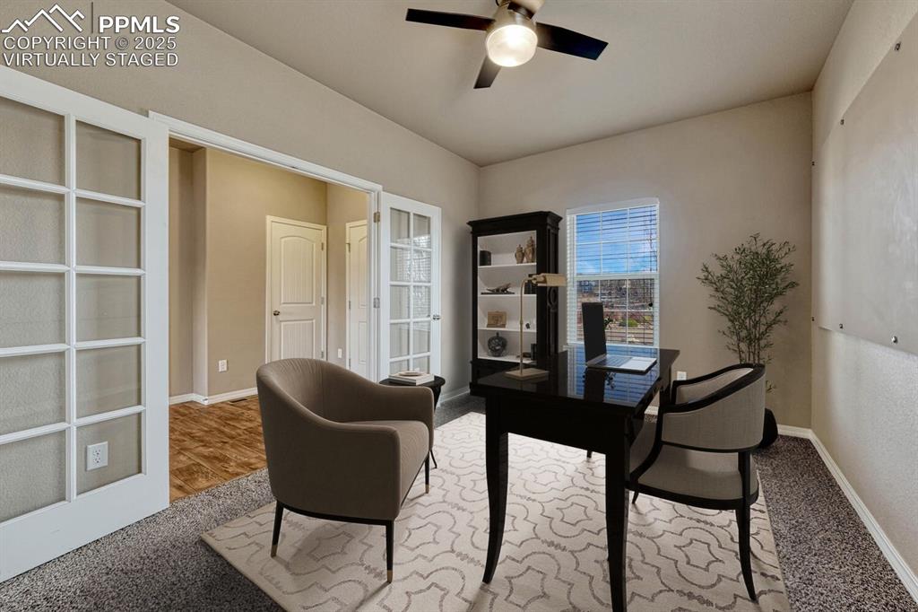 Image 12 of 50: Main level office with glass French doors. Office virtually staged.