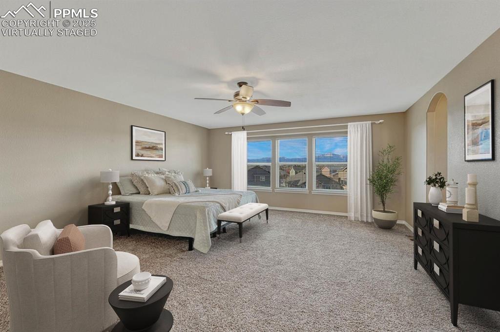 Image 15 of 50: Primary bedroom showcases full Front Range views. Bedroom virtually staged