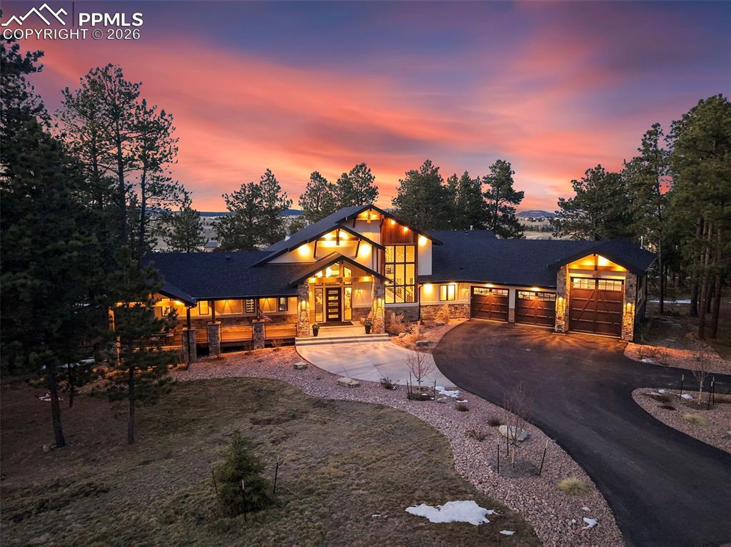 Image 1 of 50: Contemporary home with stone siding, driveway, an attached garage, and fren