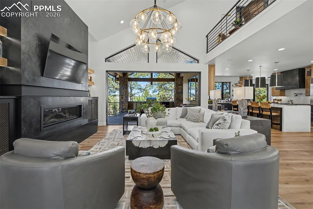 Image 8 of 50: Living room featuring a high end fireplace, wood finished floors, suspended