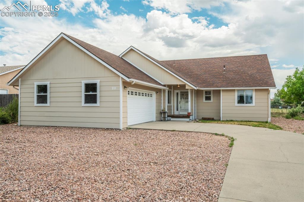 Caption: Single story home with a shingled roof, concrete driveway, a garage, and board and batten siding