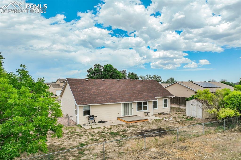 Image 33 of 42: Back of house featuring a storage unit, a fenced backyard, a deck, and a pa
