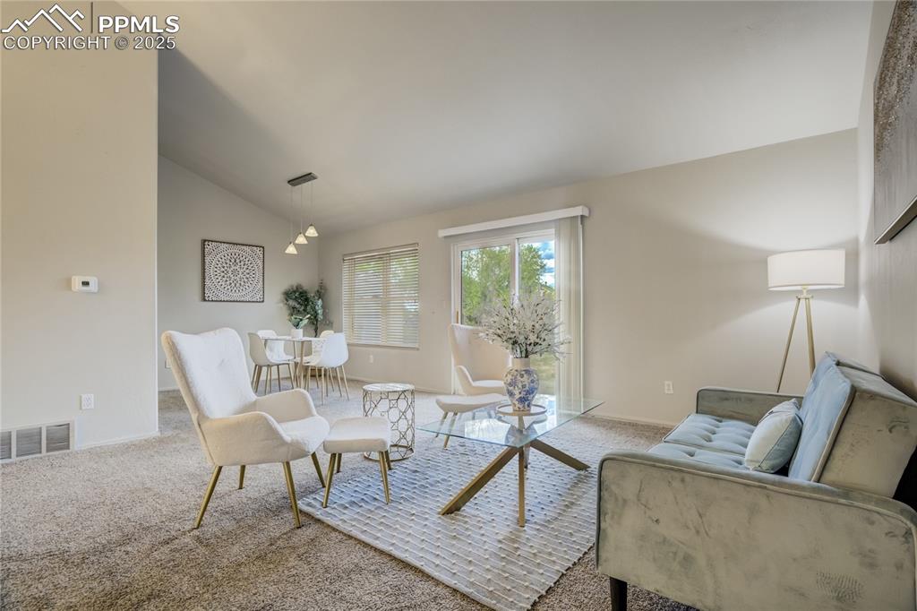 Image 5 of 42: Living room with lofted ceiling and carpet