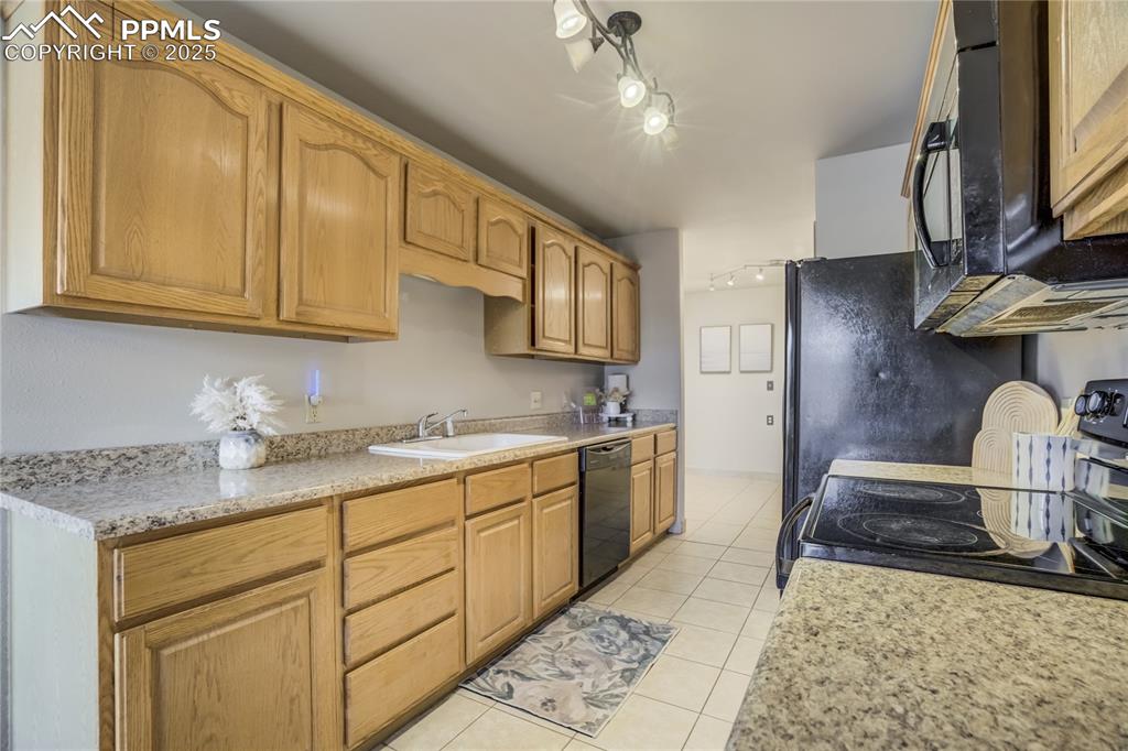 Image 8 of 42: Galley kitchen includes dishwasher, range oven, microwave, refrigerator, pa