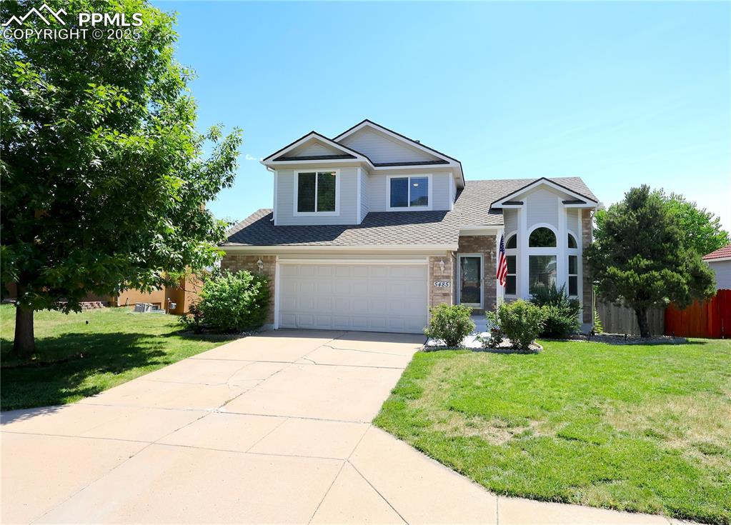 Image 2 of 39: View of front of home with concrete driveway, roof with shingles, a garage,