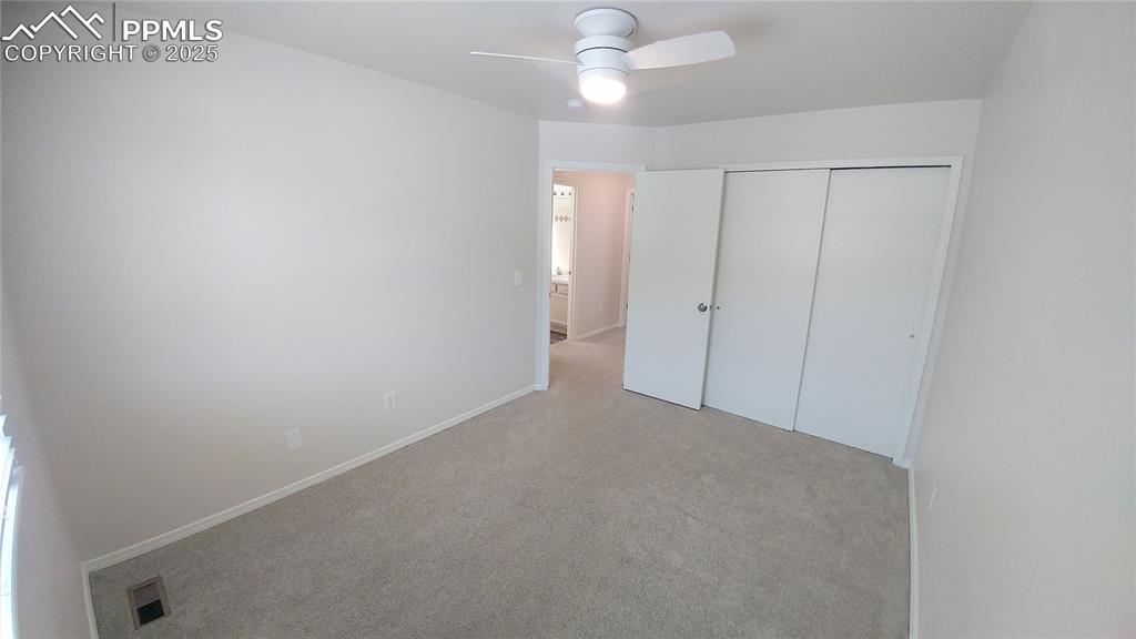 Image 20 of 39: Unfurnished bedroom with light carpet, a closet, and a ceiling fan