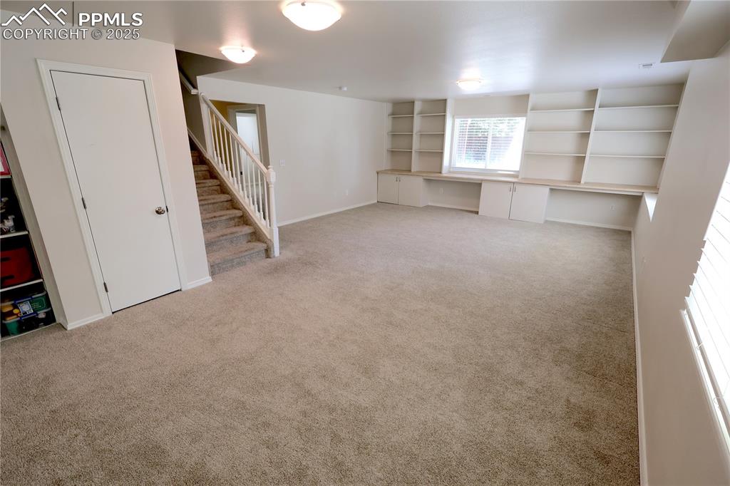 Image 25 of 39: Below grade area with stairs, carpet floors, and an office area