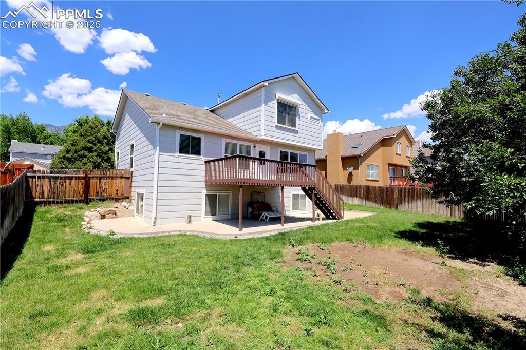 Image 33 of 39: Rear view of house featuring stairs, a patio, a wooden deck, and a fenced b
