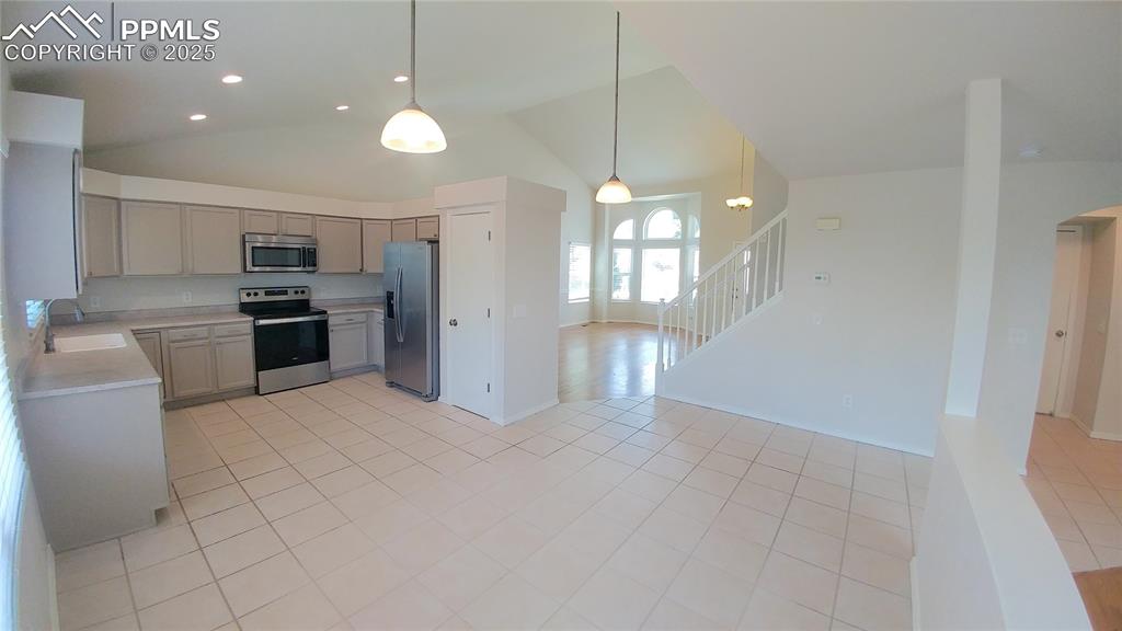 Image 7 of 39: Kitchen with appliances with stainless steel finishes, light countertops, g