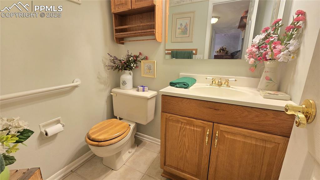 Image 22 of 42: Half bath with light tile patterned floors and vanity