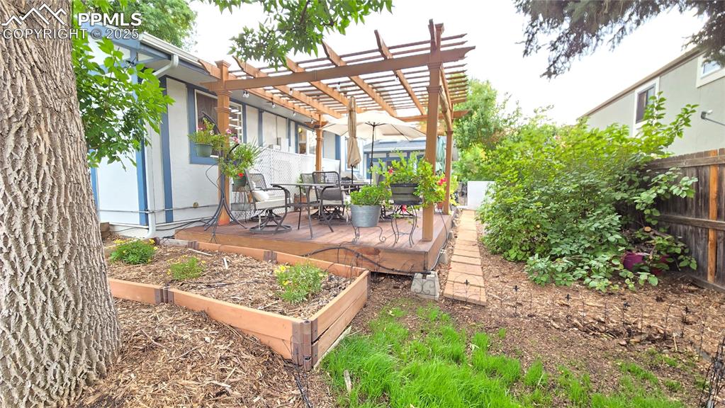 Image 36 of 42: Fenced backyard featuring a garden and a deck