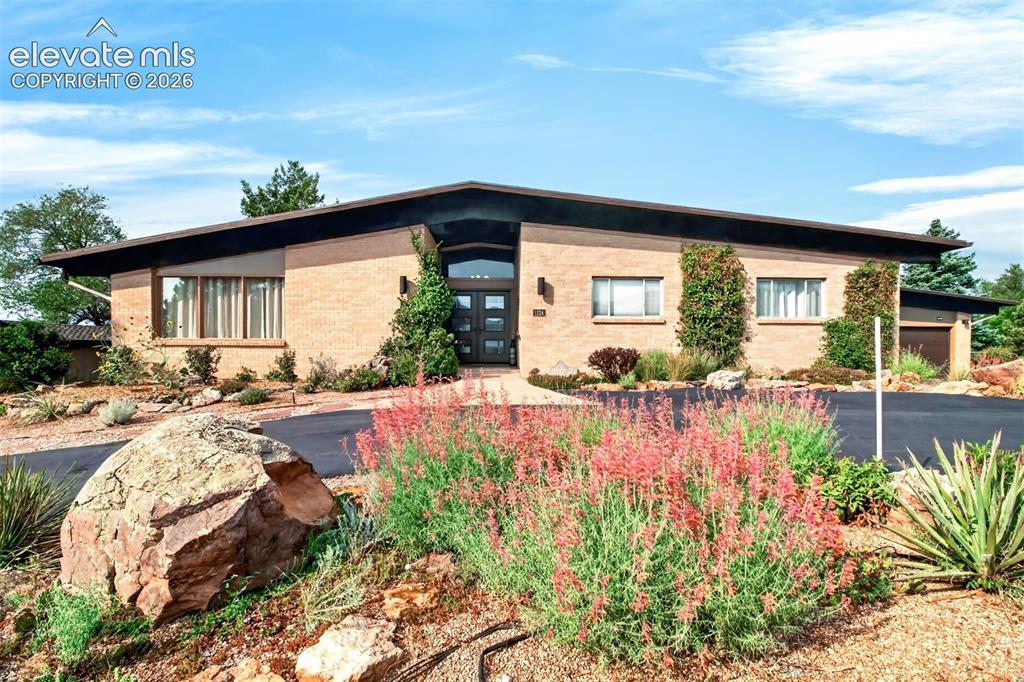 Caption: Beeautifully landscaped with a circular paved driveay