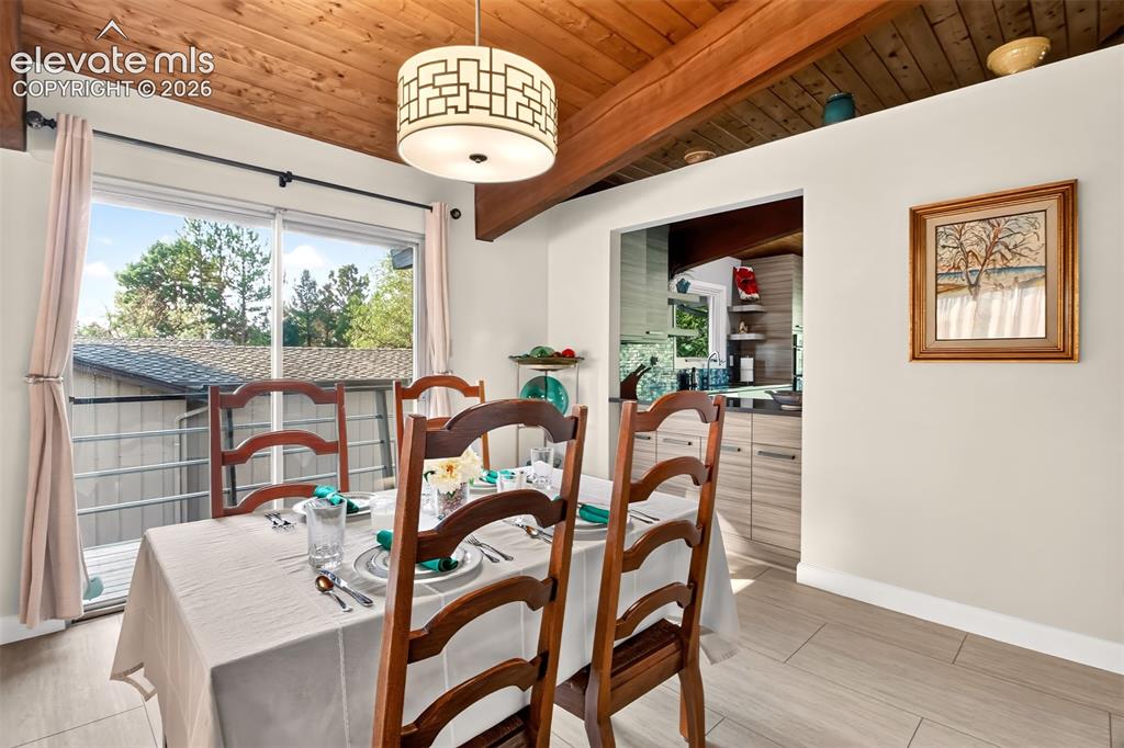 Image 11 of 49: A sliding galss door off of the dining room opens to a deck walkway that le