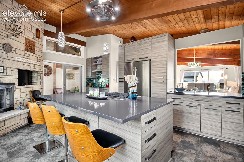 Image 14 of 49: A view of the kitchen showing the breakfast bar island, the pass through to