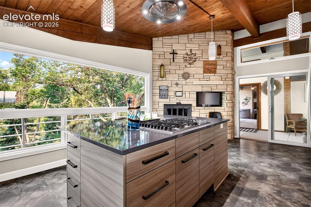 Image 15 of 49: Another view of the kitchen showing the gas 5 burner downdraft cooktop and 