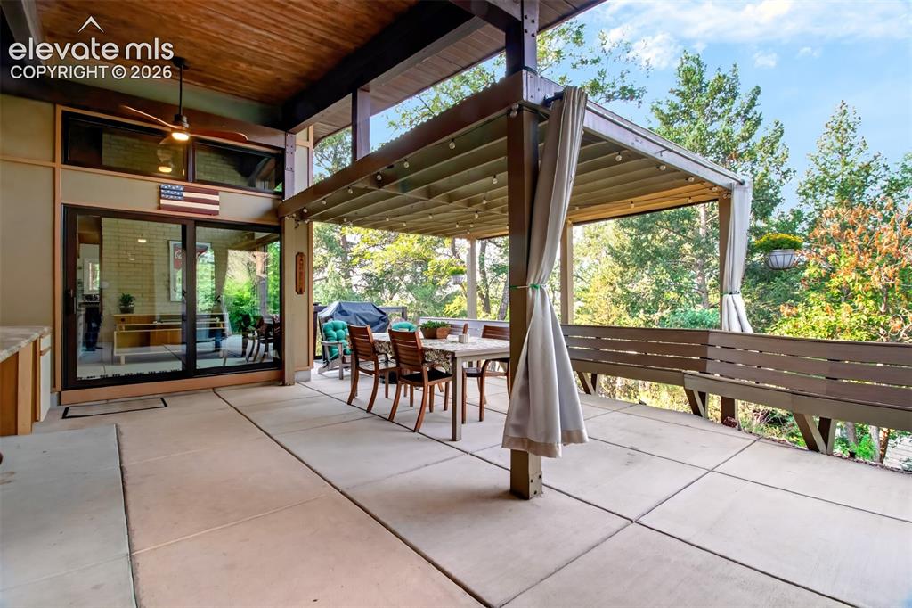 Image 20 of 49: The large patio has a pergola for covered seating, and built-in bench eatin