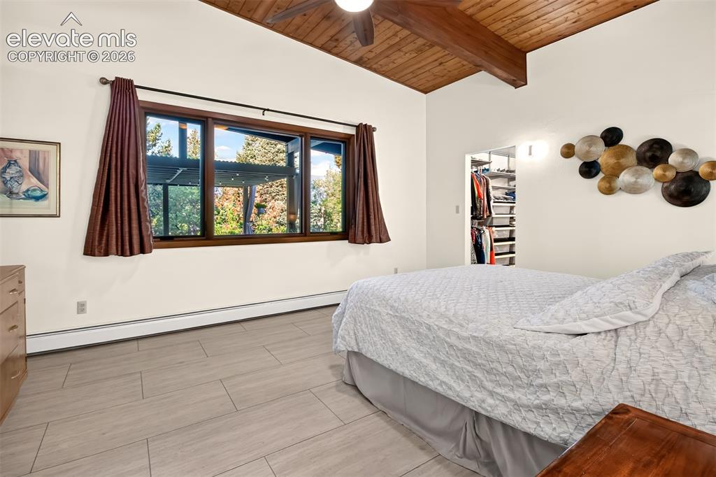 Image 24 of 49: The primary bedroom has windows overlooking the patio