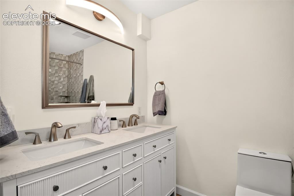 Image 26 of 49: Double sink vanity and updated lighting in the private primary bath