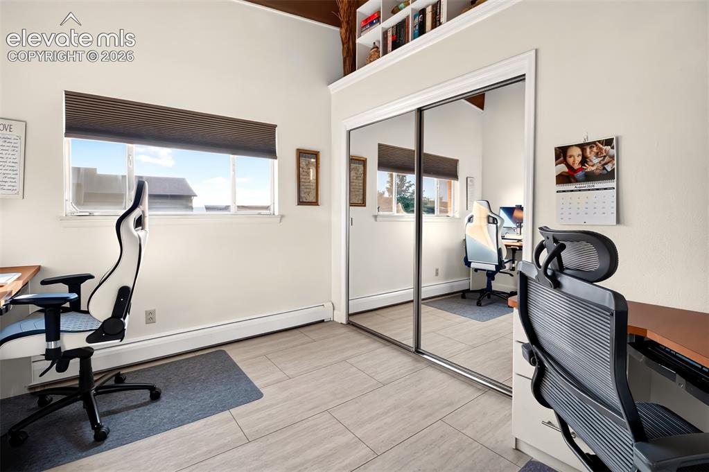 Image 29 of 49: A secondary bedroom on the main level  has shelves and clothes rod in the c