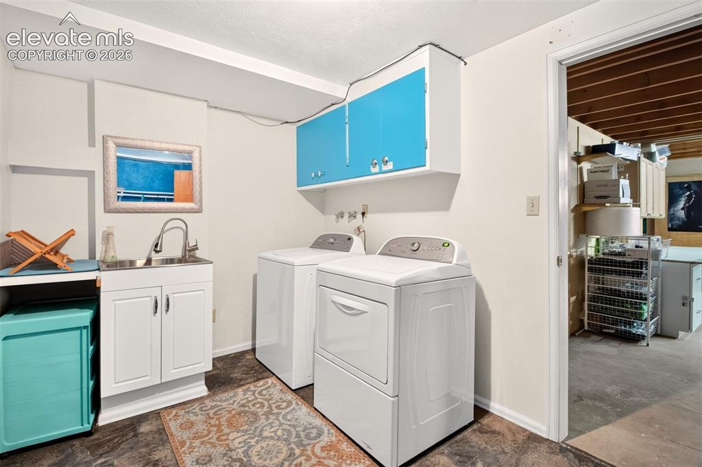 Image 43 of 49: Ihe laundry area comes complete with washer, dryer, sink, and loads of stor