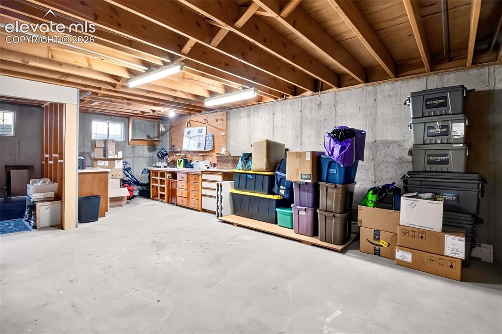 Image 44 of 49: A workbench and cabinets, a rough in 5th bath area-potential galore!