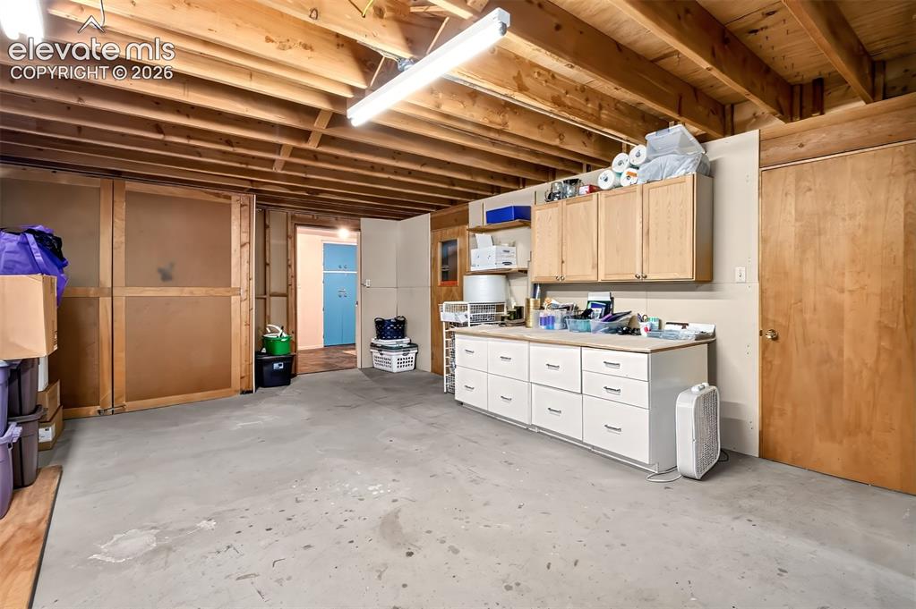 Image 45 of 49: Off of the laundry area, this unfinished basement space is filled with stor
