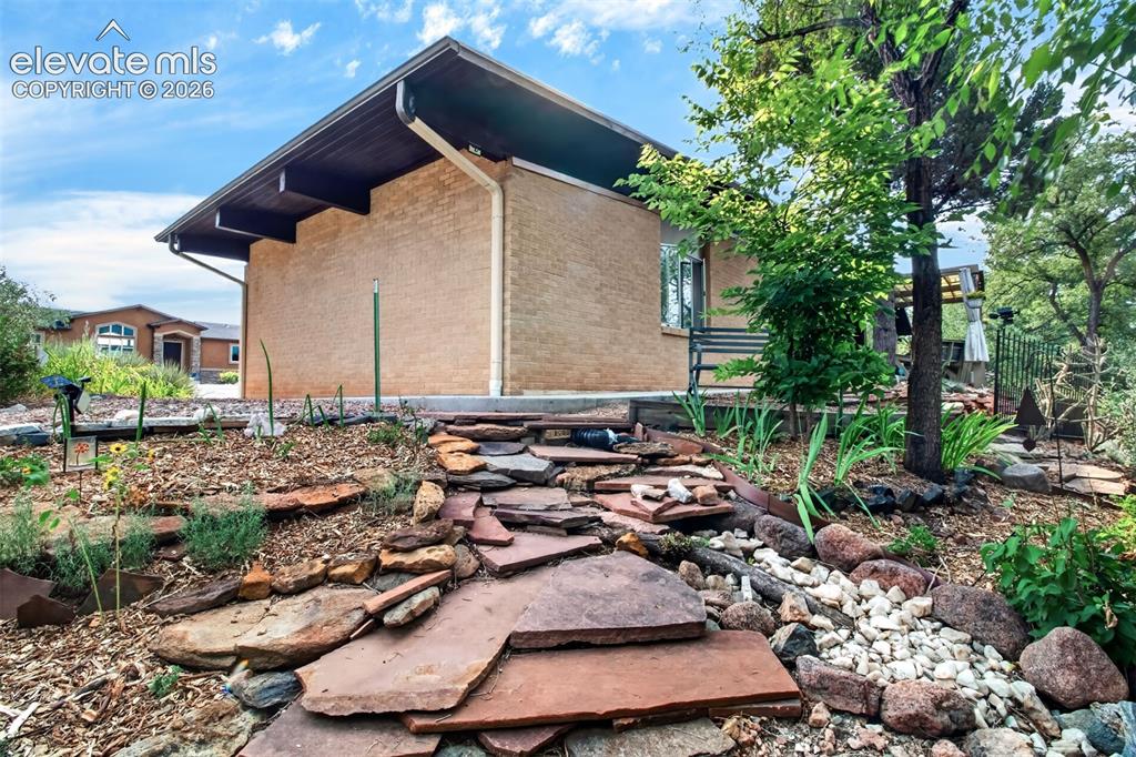 Image 48 of 49: Looking at the side of the home fromo ne of the flagstone walkways